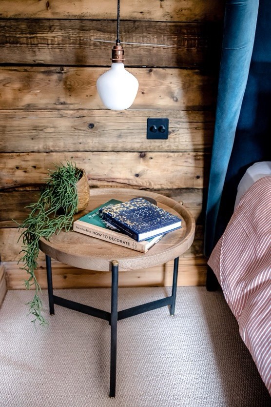 Reclaimed timber clad bedroom wall with a round oak side table – USFEW carpentry, Kent
