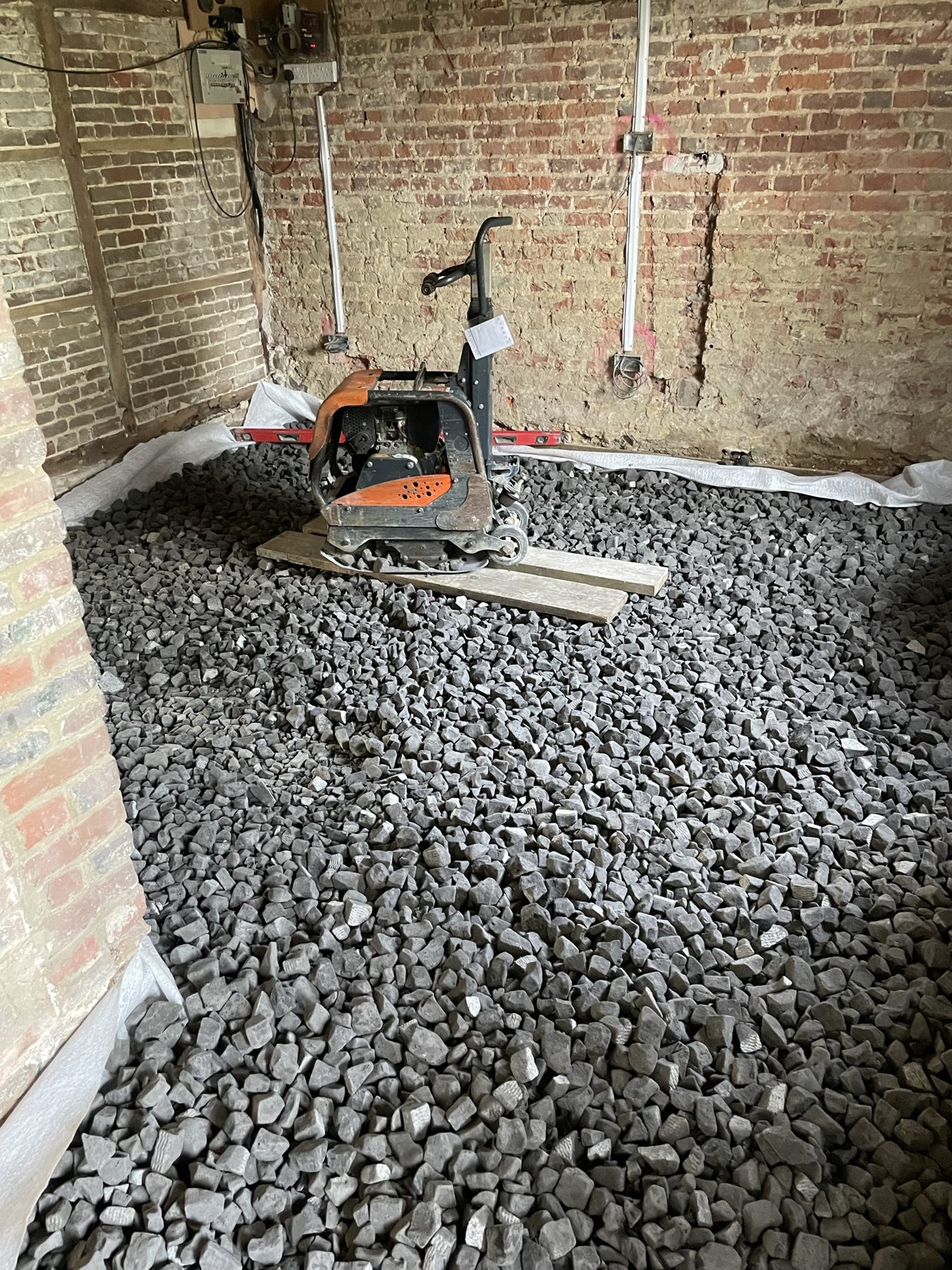 Foamed glass insulating base being compacted with a plate compactor – limecrete floor, Kent