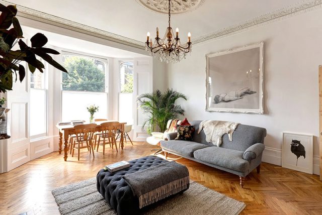 Living room with reclaimed parquet flooring and resorted windows