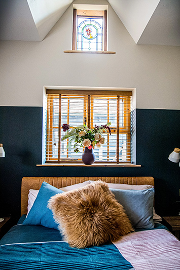 A a modern rustic two-bed country stable with heaps of natural wood beams balanced with modern fixtures